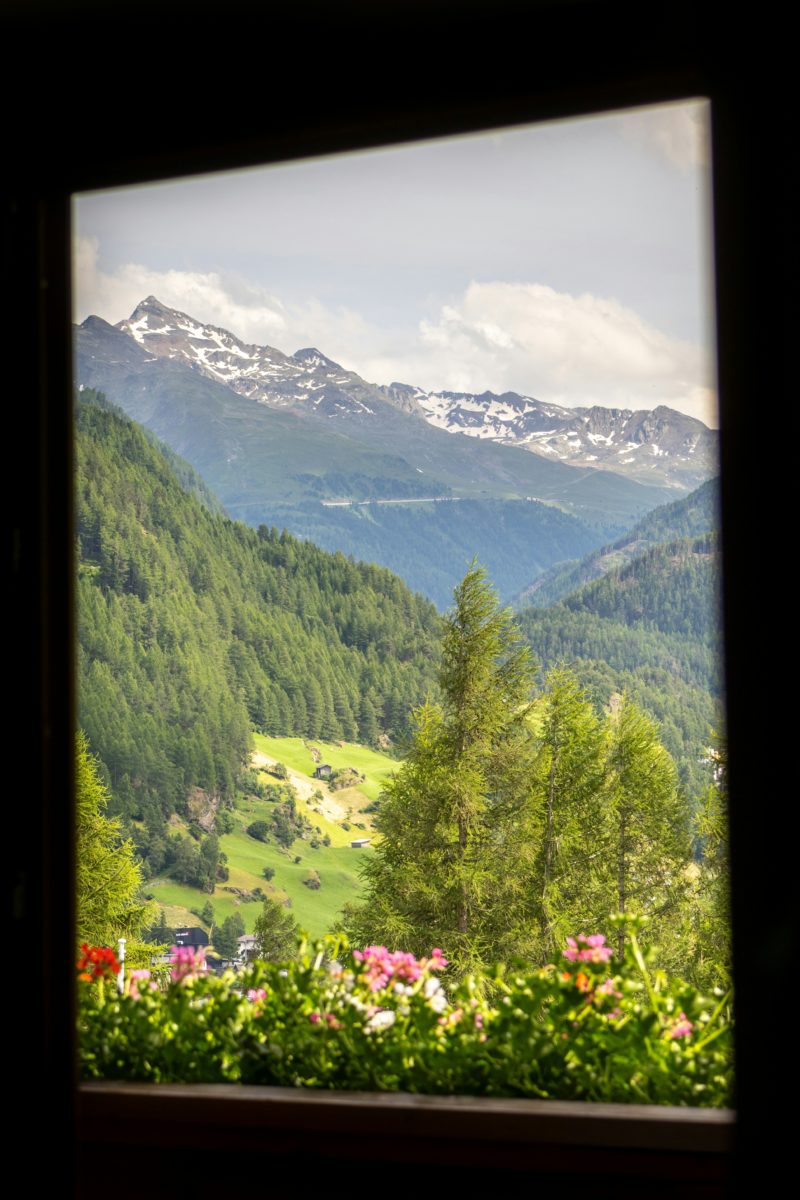 A window with a view of a valley and mountains